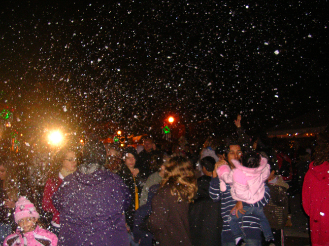 fake snow falls on a city event