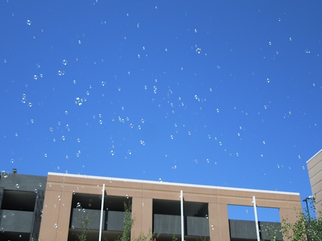 bubbles fly high over head at a event
